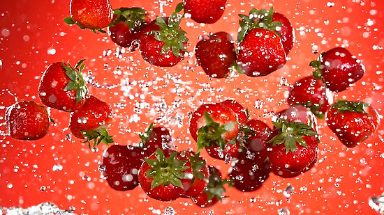 fresh strawberries flying in the air with water splashes